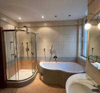 A bathroom in a 3-room apartment with a bathtub, a shower, and a sink.