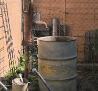 A water pump with a metal barrel in the garden of a family house in Partizánske.
