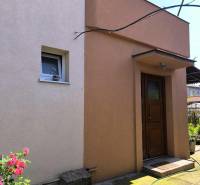 A family house in Partizánske with colored plaster and a garden.