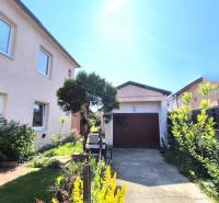 A family house in Partizánske with a landscaped garden and a garage on a quiet street.