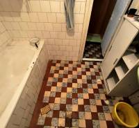A bathroom in a family house with retro tiles and a bathtub.