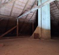 The attic of a family house with wooden beams and ceramic roofing tiles.