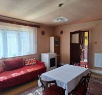 The interior of a family house with a sofa, dining table, and stove.