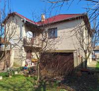 A family house in Tachtoch with a red roof, a garden, and a satellite dish.