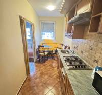 A kitchen in a 3-room apartment with upper cabinets, a stove, and a tiled floor.