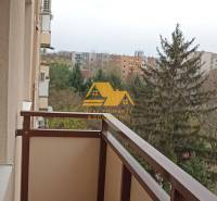 A balcony in a 2-room apartment with a view of greenery and rooftops in Nové Zámky.