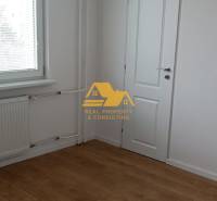 A view of a room with white walls and a floor with a wooden decor in a 2-room apartment.