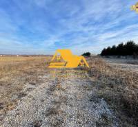 Land for residential use in Nové Zámky on Nové Zámky street, gravel road, open landscape.