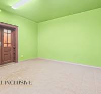 Green room with light walls, floor with wood decor, door in a family house.