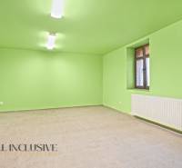 A spacious room in a family house with green walls and tiles.