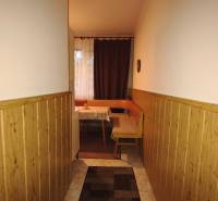 A narrow hallway leading to the dining room with a bench in a 3-room apartment.