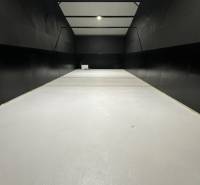 A garage with a white floor and black walls, lighting, empty space.
