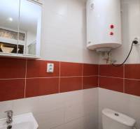 Bathroom with a white boiler, sink, and mirrored cabinet in a 2-room apartment.