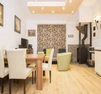 Dining area in a 2-room apartment with a wood-patterned floor and a fireplace.