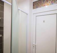 A bathroom with a combination of white and dark tiles in a 2-room apartment.