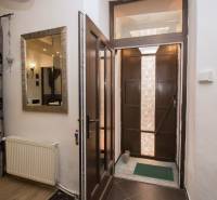 Entrance hallway with wooden doors, a mirror, and curtains in a 2-room apartment.