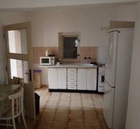 A kitchen in a family house with white cabinets, a microwave, and a refrigerator.