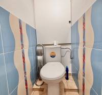 Colorful tiles and a toilet in a 2-room apartment with bold geometric patterns.
