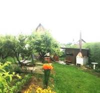 The garden at the cottage in Pozdišovce with a gazebo and greenery, ideal for relaxation.