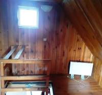 Interior of a cottage with a wooden decor floor and a staircase.