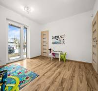 Children's room in a family house with a wooden decor floor and toys.