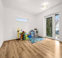 Children's room with toys and a wooden-decor floor in a family house.