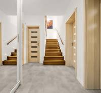 Entrance hall in a family house with a wooden decor floor and a staircase.