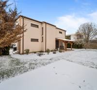 A family house on Konopiská Street in Bratislava - Čunovo with a snow-covered garden.