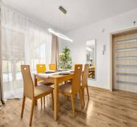 A dining room with a wooden table and a wooden decor floor in a family house.