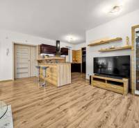 Living room in a family house with a kitchen and a wooden decor floor.
