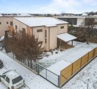 Family house in Bratislava - Čunovo on Konopiská Street, snowy street, parked cars.