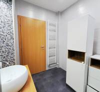 Bathroom with a sink, white cabinets, and mosaic tiles in a 2-room apartment.