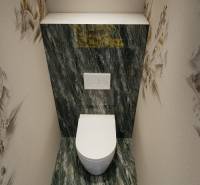 A toilet with marble tiles and patterned walls in a 3-room apartment.