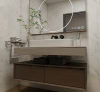 A bathroom in a 3-room apartment with a wooden decor floor, a mirror, and a sink.