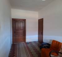 Interior of a family house with doors, an armchair, and a carpet runner.