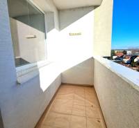 The balcony of a 4-room apartment, overlooking the rooftops and a clear sky.