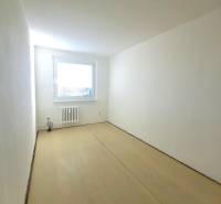 A room in a 4-room apartment with white walls and a wooden decor floor.