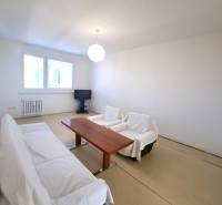 Living room with a table and a sofa in a 4-room apartment, floor with wood decor.