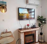 Interior of a holiday apartment with a fireplace, television, and dining table.