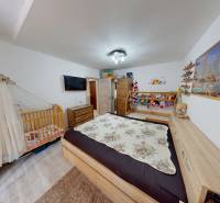 Children's room in a two-room apartment with a crib, bed, and floor with a wooden decor.