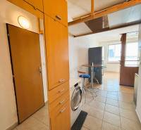 Entrance hall of a 2-room apartment with tiles and an equipped kitchenette.