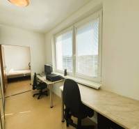 A study with a desk and a chair, a floor with a wooden decor, large windows, a 2-room apartment.