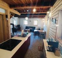 A cottage with wooden elements and tiles, a floor with a wooden decor, a kitchen island.