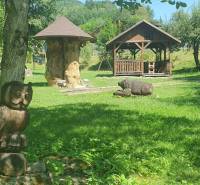 The garden on Hviezdoslavova Street in Tisovec with wooden sculptures near the cottage.