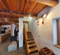 Wooden stairs in a cabin with a wood-decor floor, with Christmas decorations.