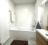 Bathroom in a 3-room apartment with a bathtub and a sink, tiles on the walls.