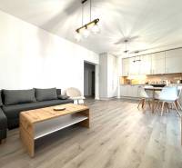 Spacious living room in a 3-room apartment with a kitchen and a floor with a wooden decor.