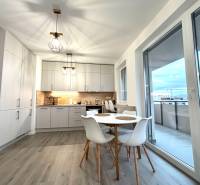 A kitchen in a 3-room apartment with a wooden decor floor and a balcony.