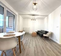 Living room in a 3-room apartment with a sofa, table, and wooden decor flooring.