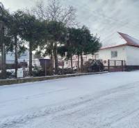 A family house on Hájska Street in Martin with a snow cover and trees in the garden.